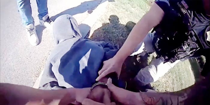 a black teenager is held down and handcuffed by police