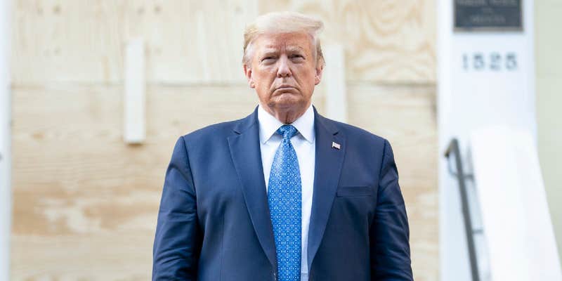 President Donald Trump standing in front of a vandalized church