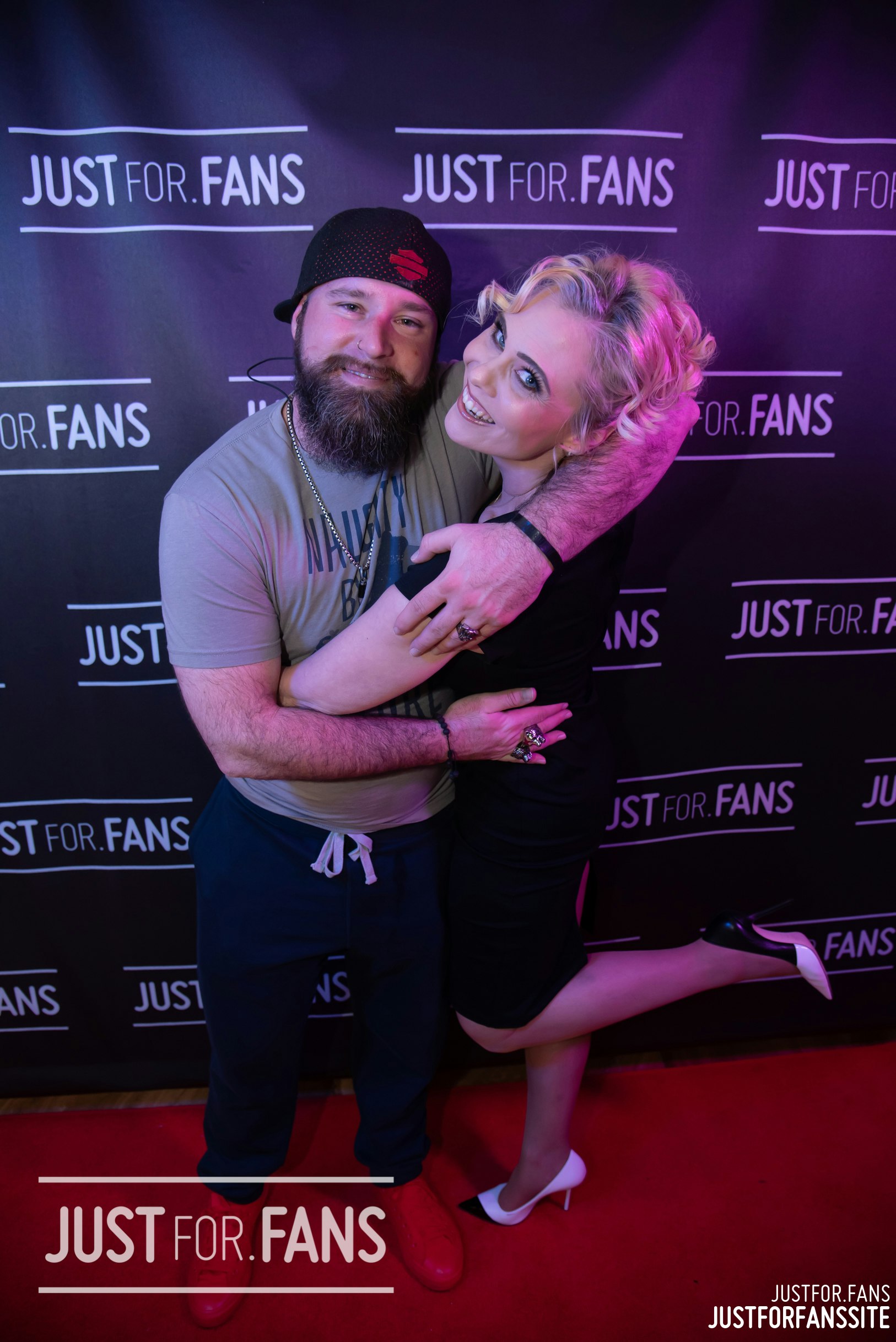 A photo showing two Justfor.fans models hugging on a red carpet