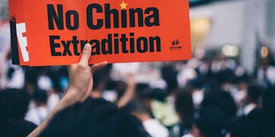 A protesters in Hong Kong holding up a sign
