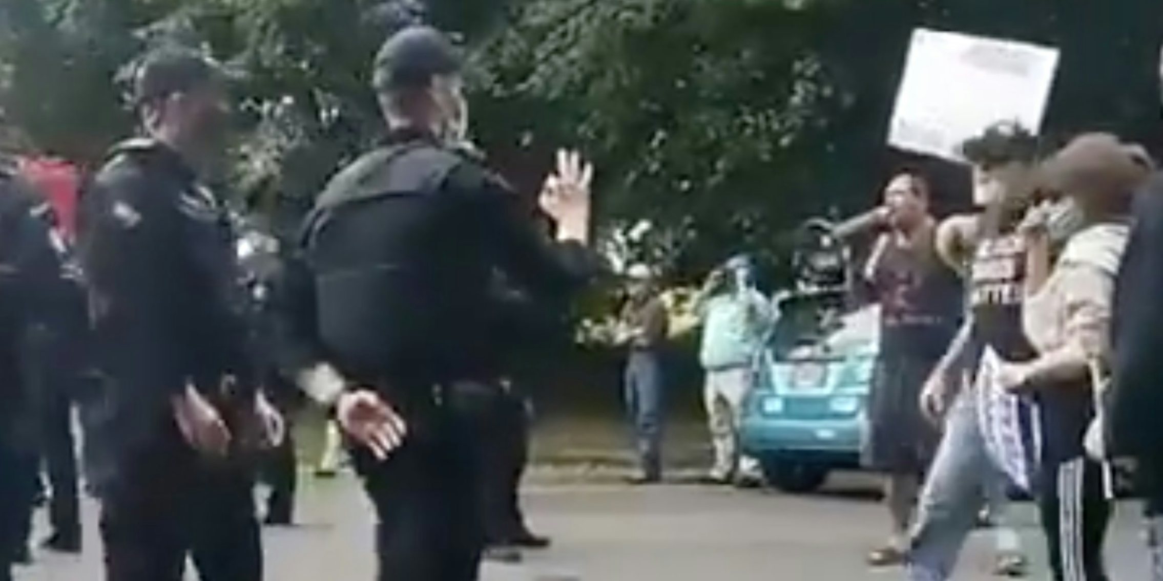 An Oregon police officer using the 'OK' hand signal