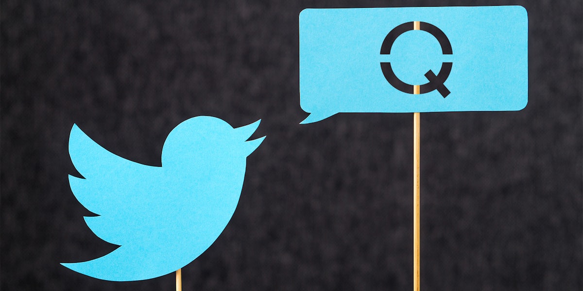 twitter bird on stick with speech bubble that is filled with a cutout Q