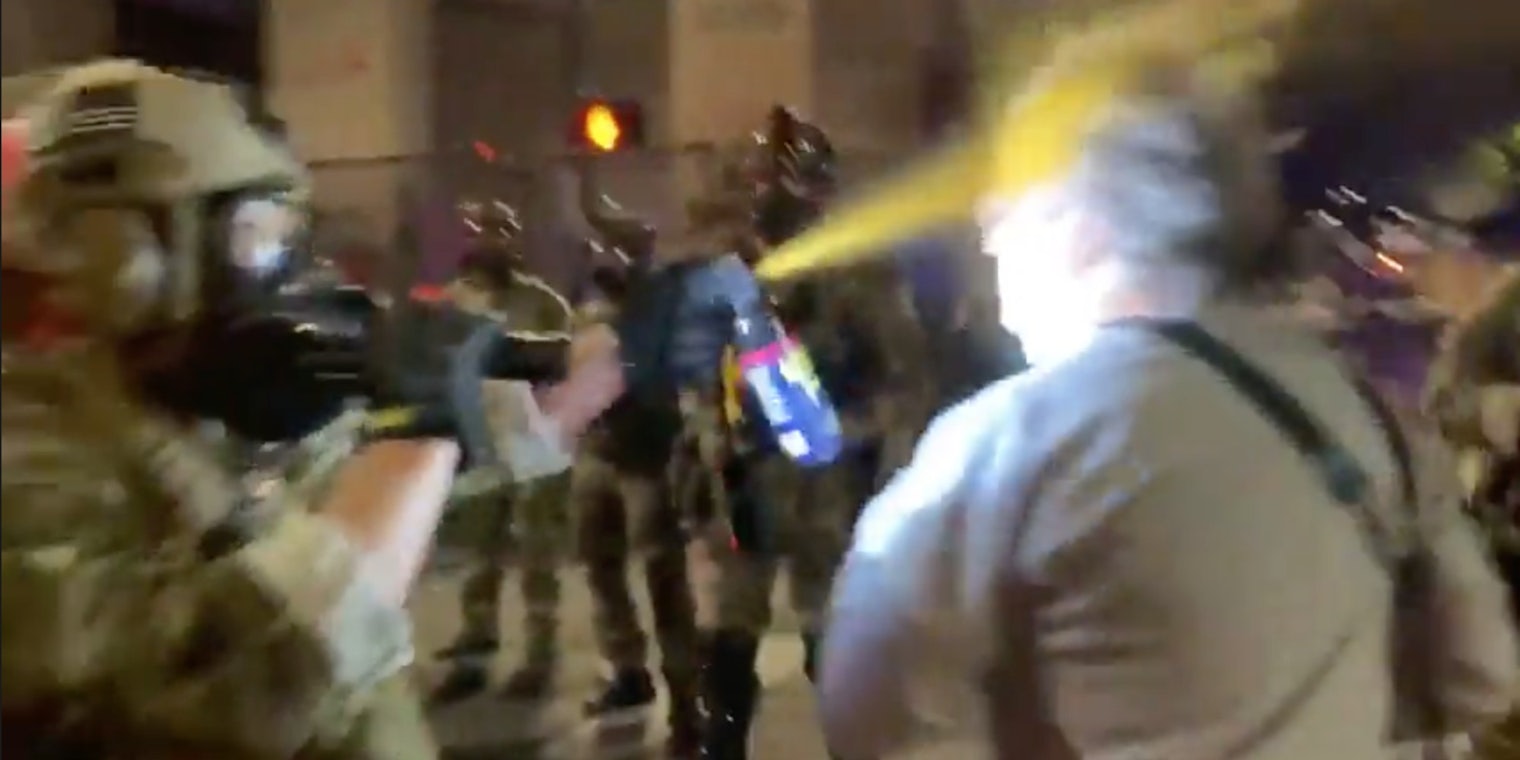 A man being pepper-sprayed in the face by police