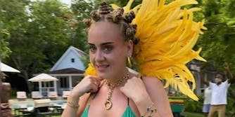 adele wearing jamaican flag top and bantu knots with yellow feathers