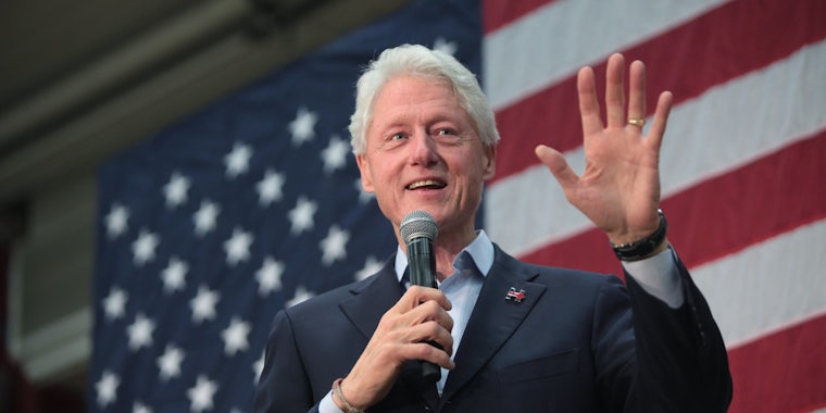 President Bill Clinton speaking in front of an American flag