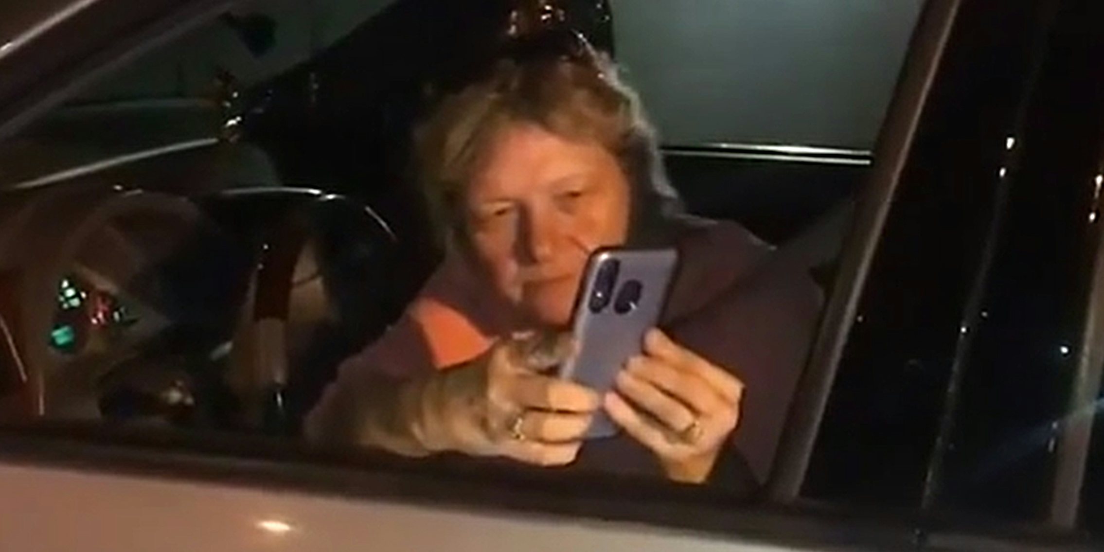 woman filming stranger from car