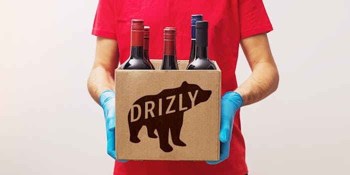 man with gloves delivering wine in a Drizly-branded cardboard box