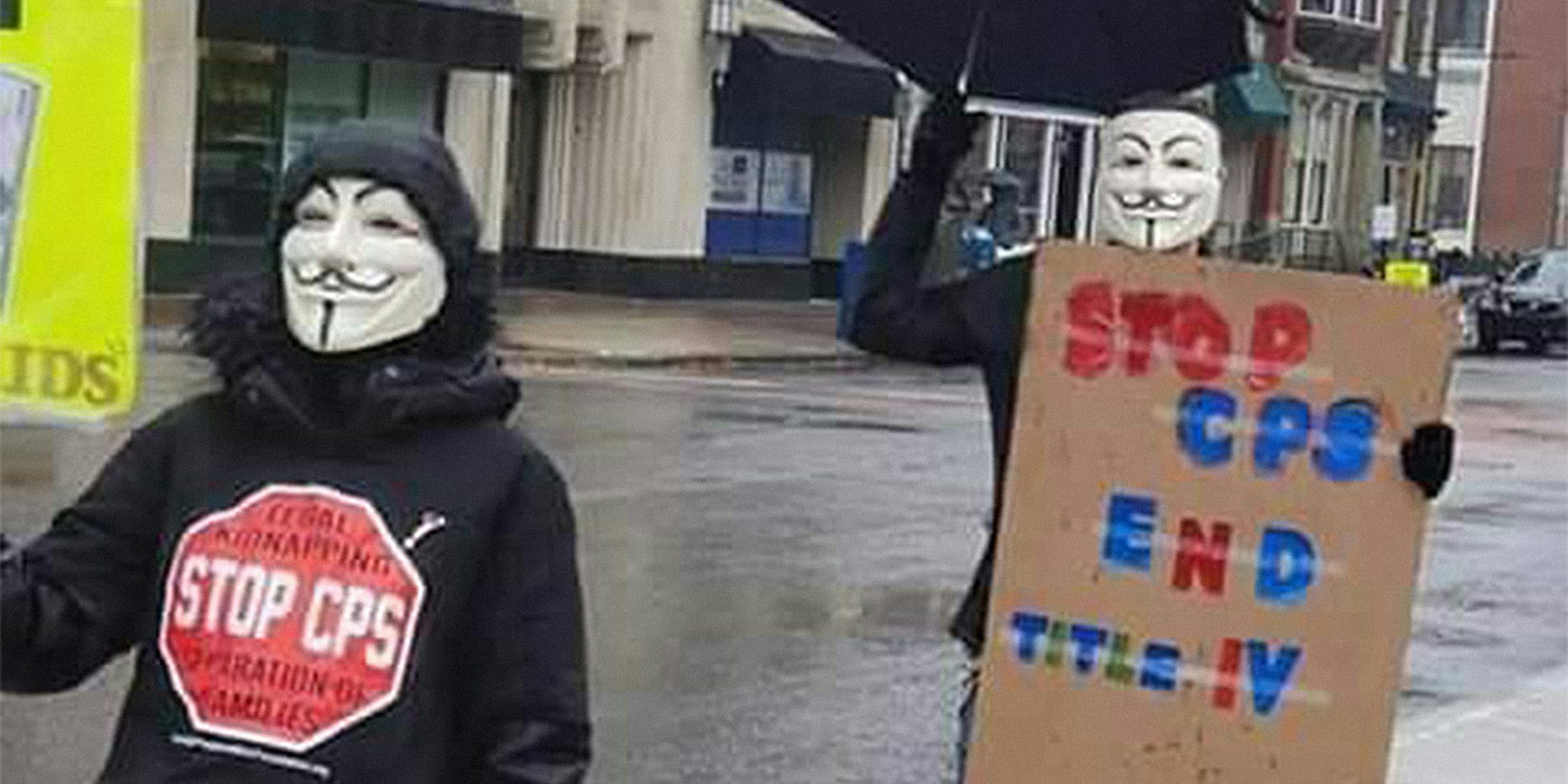 people wearing guy fawkes masks carrying 'stop cps' signs