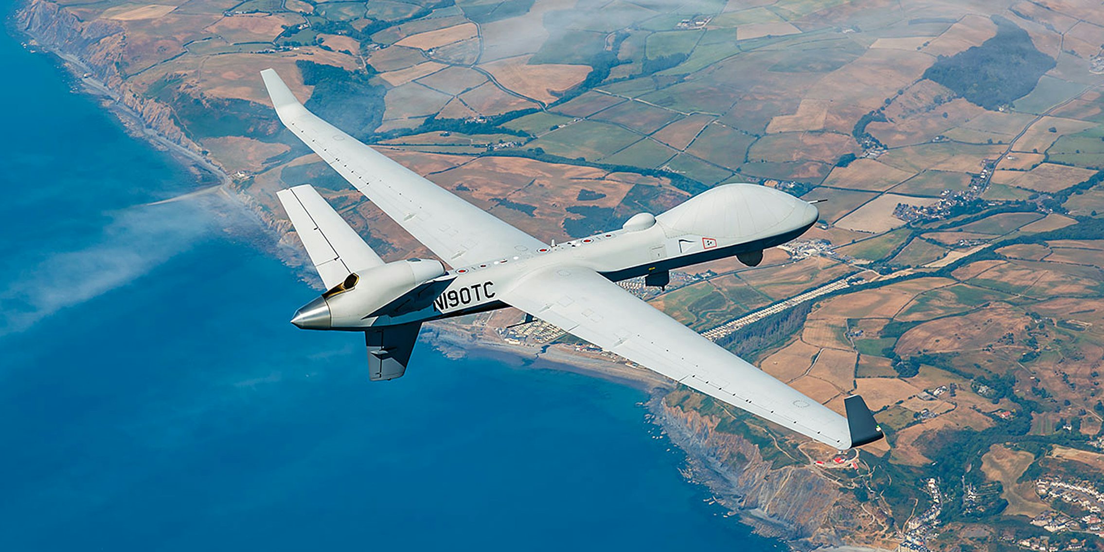 general atomics rebranded predator drone flies over coastline
