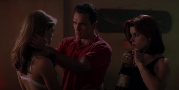 A hulu porn scene from wild things showing a man embracing a woman while another woman looks on