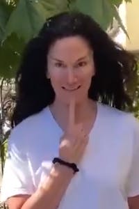 woman with peaked eyebrows and index finger on chin