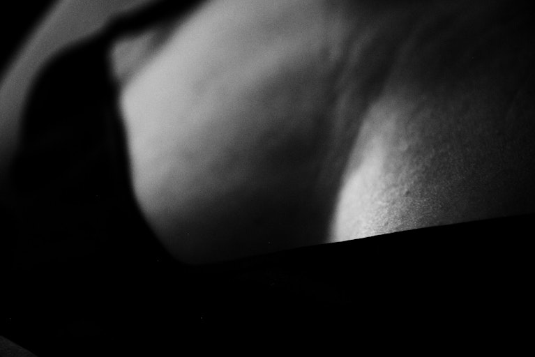 A close-up of a woman's breasts in black and white.