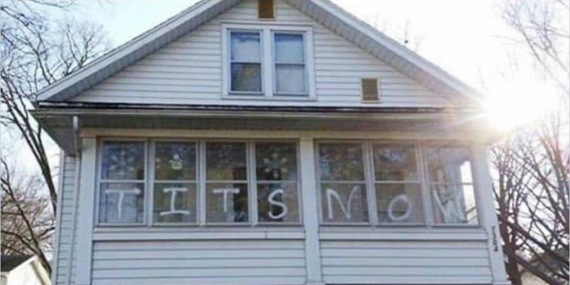 photograph of a house showing tits now written on the windows