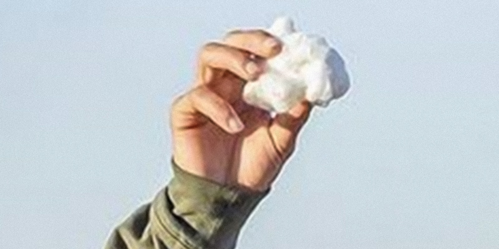 man holding bit of cotton