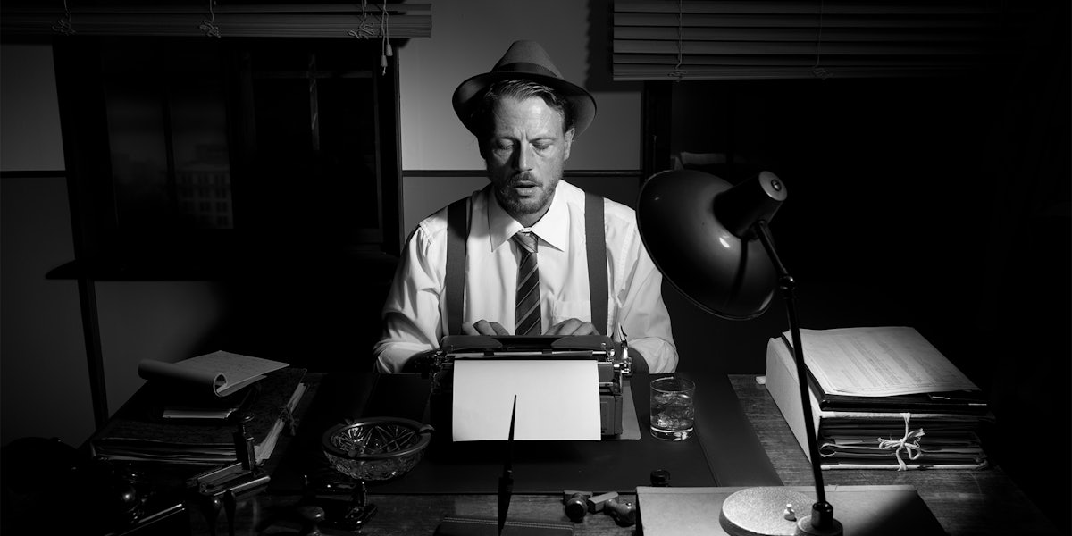 reporter in hat using typewriter
