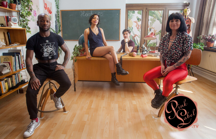 Image of four adults sitting in a classroom with a chalkboard that has "hookups" written on it behind them.