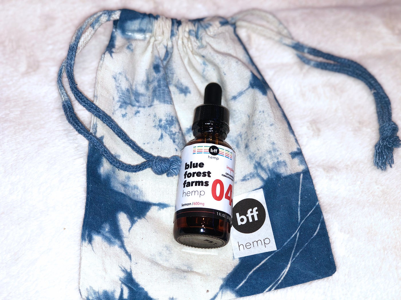 Blue Forest Farms cbd-v bottle and blue tie dye bag