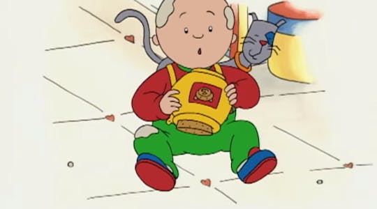 Photo of Caillou playing with his cat.