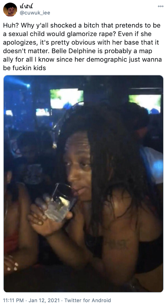 "Huh? Why y'all shocked a bitch that pretends to be a sexual child would glamorize rape? Even if she apologizes, it's pretty obvious with her base that it doesn't matter. Belle Delphine is probably a map ally for all I know since her demographic just wanna be fuckin kids" image of a Black woman with dreadlocks drinking in a bar and looking deadpan