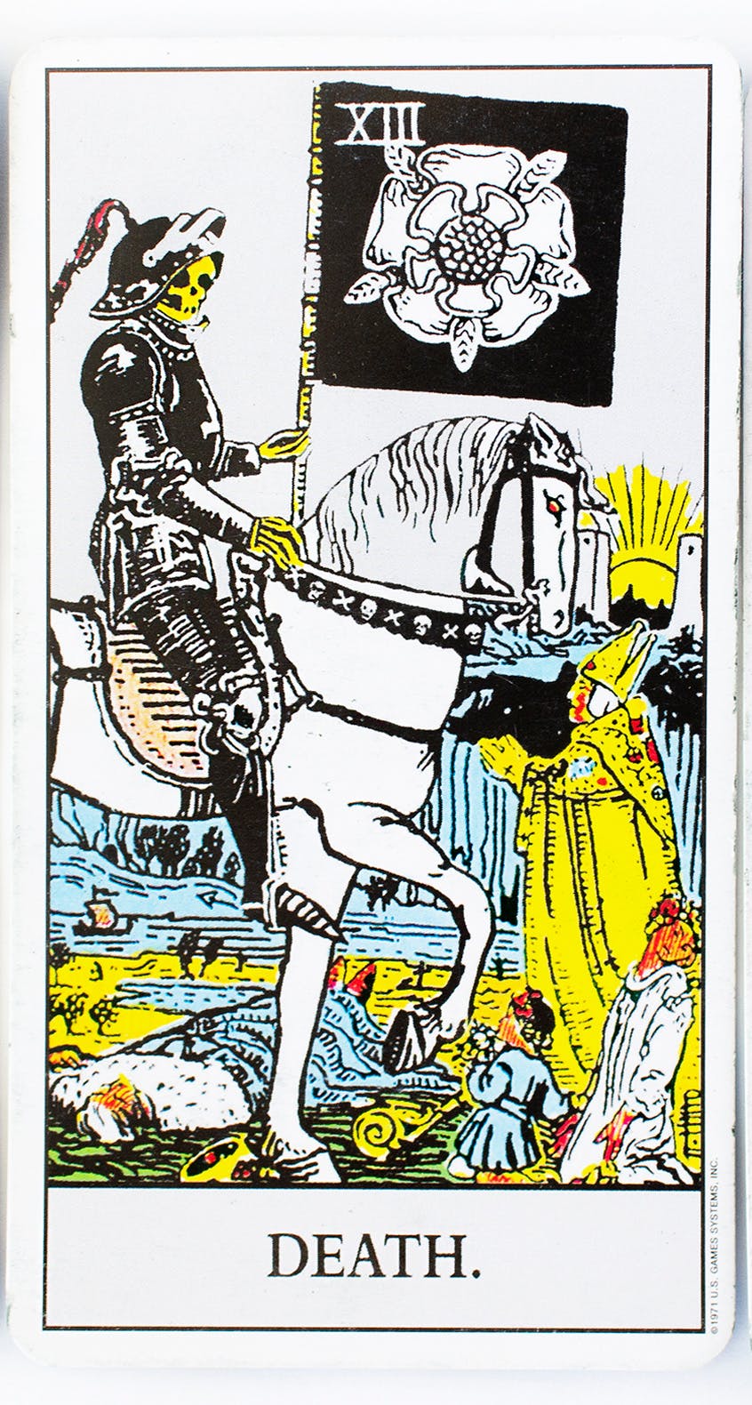 teh death tarot card from the rider-waite deck. image of a skeleton riding a horse while holding a sickle and common people being crushed underneath.
