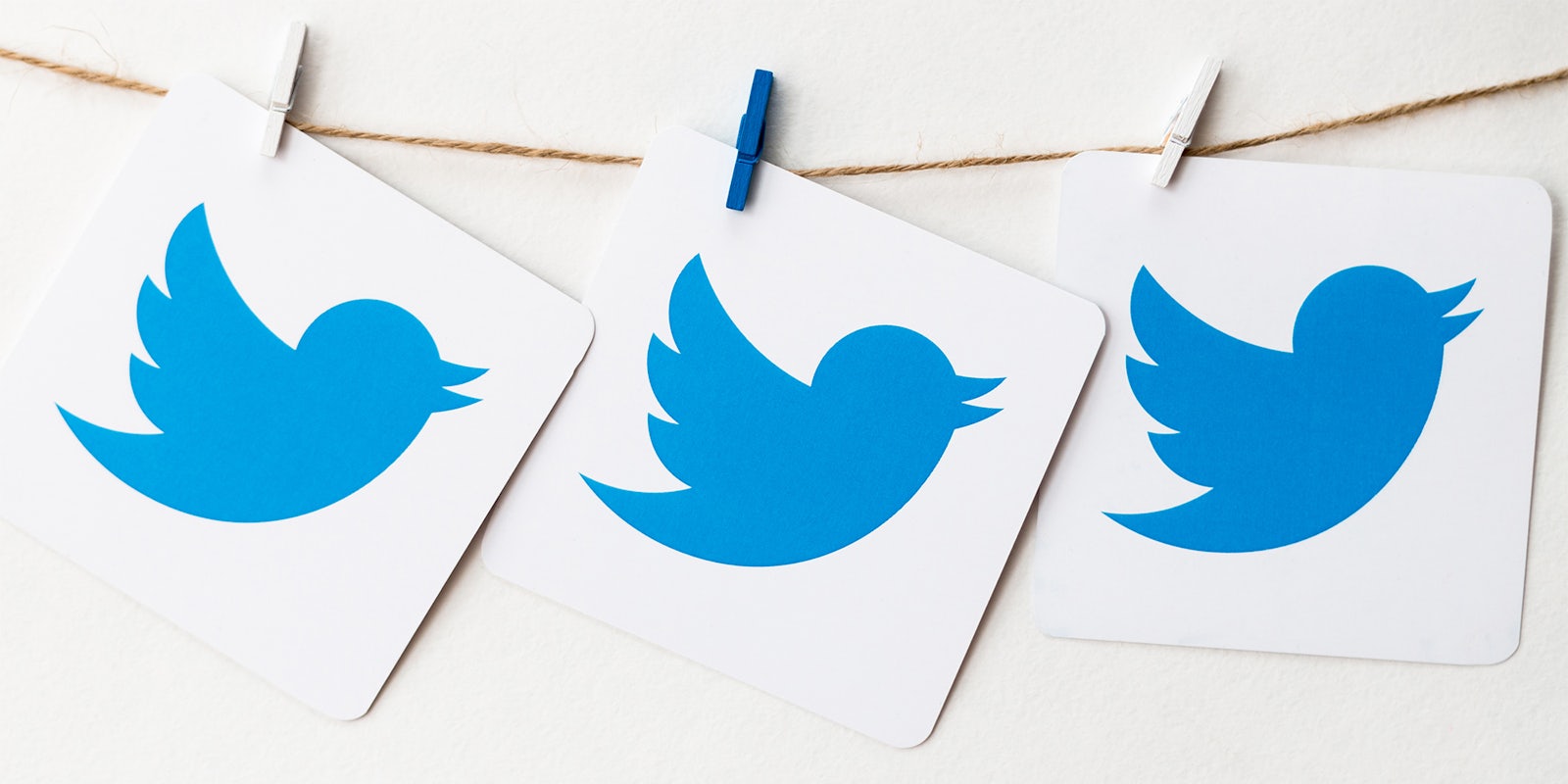twitter logos on cardboard, hanging from a string
