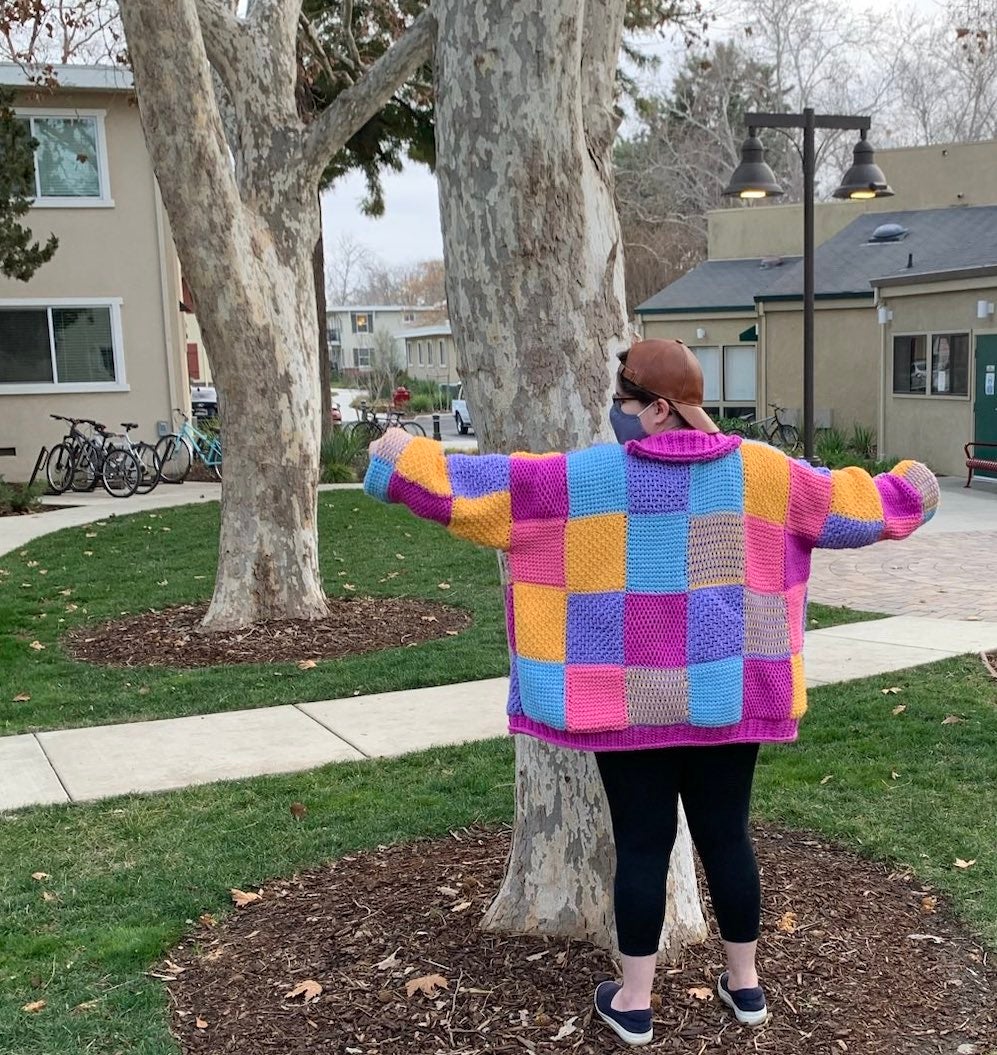 An image of a person showing off their homemade Harry Styles cardigan.