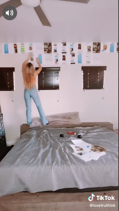 girl gluing pages on wall