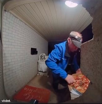 pizza delivery man at customer's front porch touching pizza in box