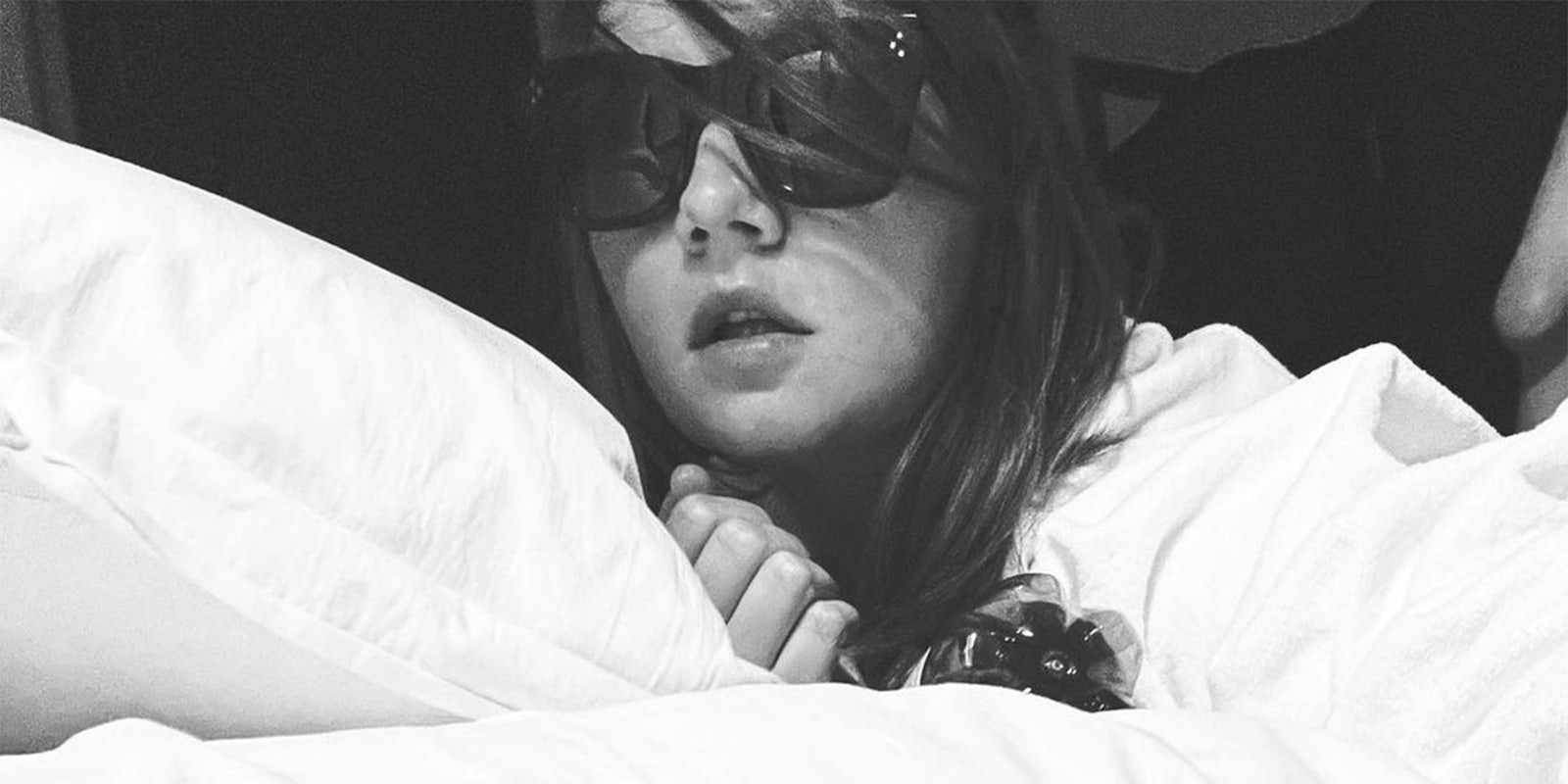young woman with sunglasses in bed