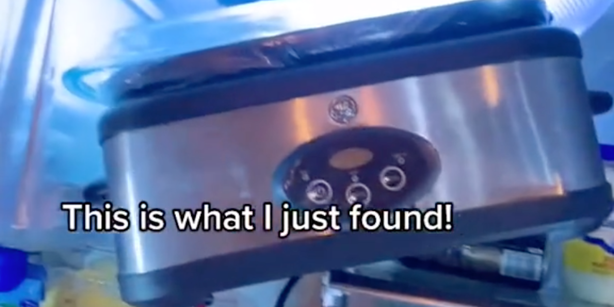 a slow cooker at an angle on top of groceries in a fridge with the text "This is what I found!"