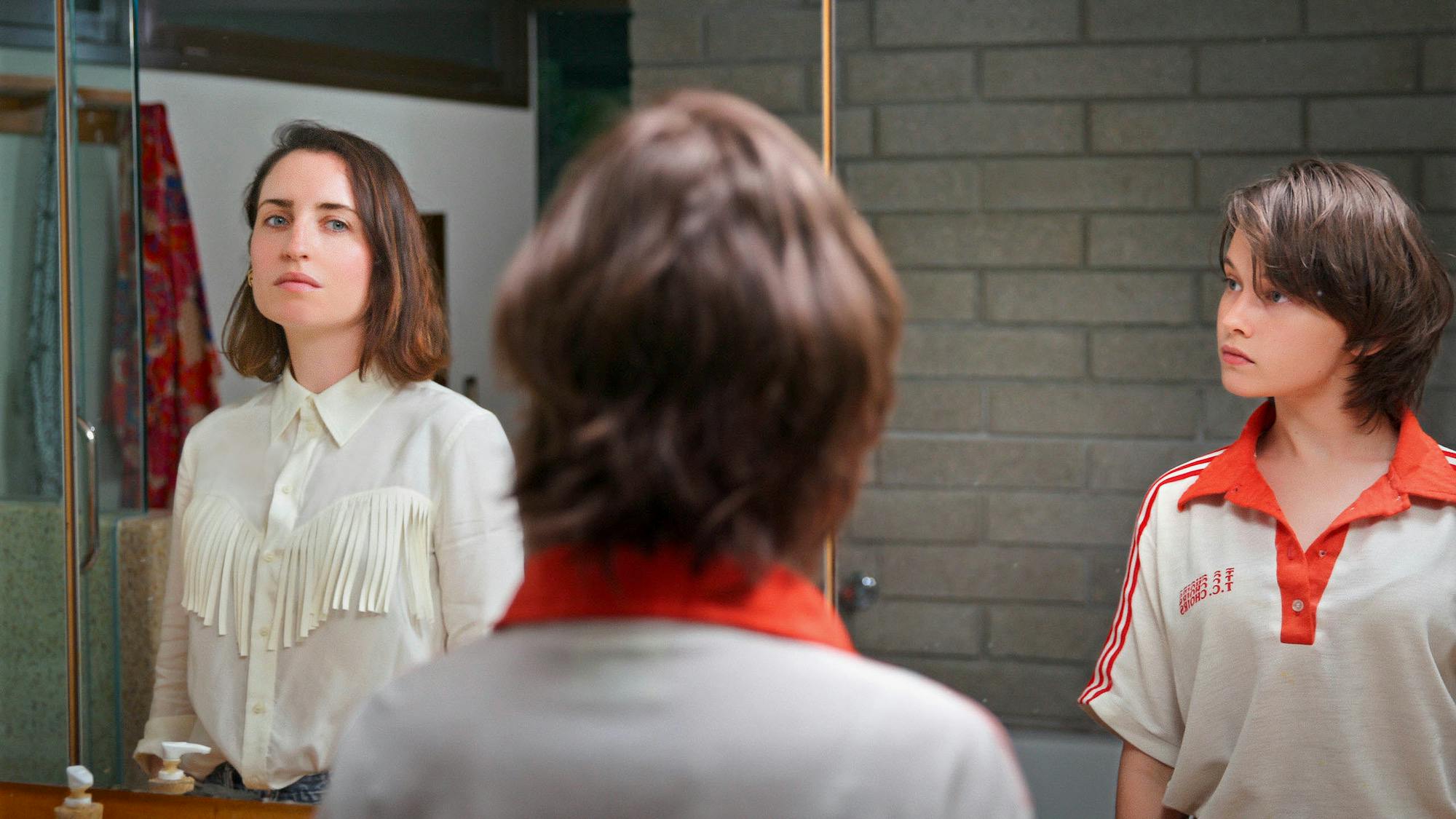 two women look at each other in front of mirror