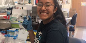Alondra Carmona posing with lab gear - college savings