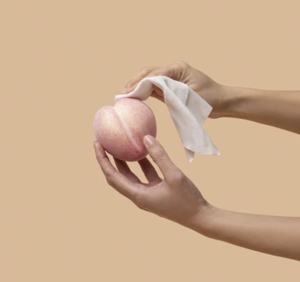 Cake's Bottoms play wipe being used on a peach.