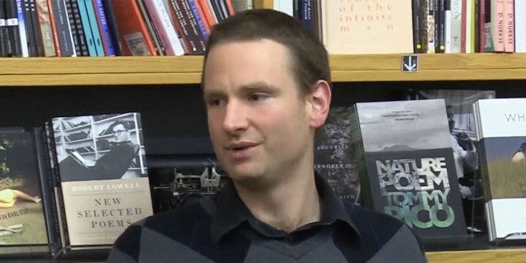 Alexander Reid Ross in front of a bookshelf