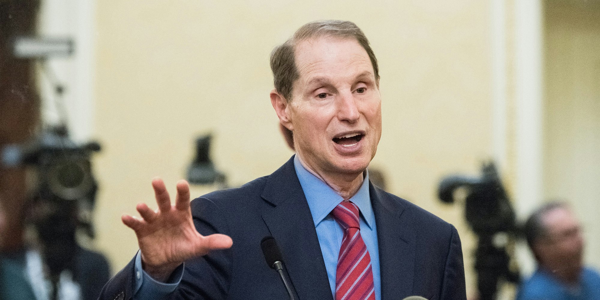 Sen. Ron Wyden speaking at a podium.