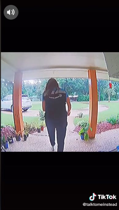 amazon delivery driver walking away from front porch with package in hand