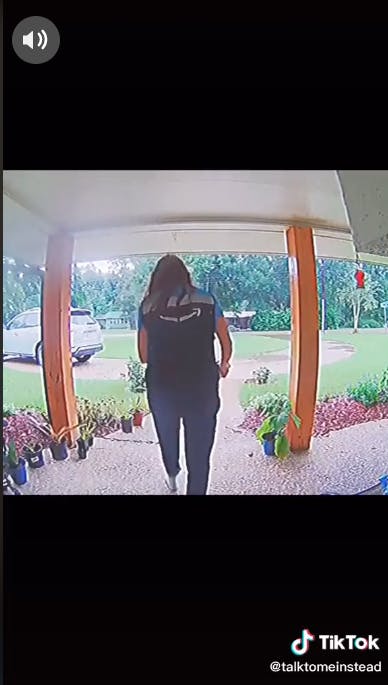 amazon delivery driver walking away from front porch with package in hand