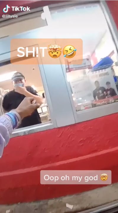 fast food worker at window in drive-thru