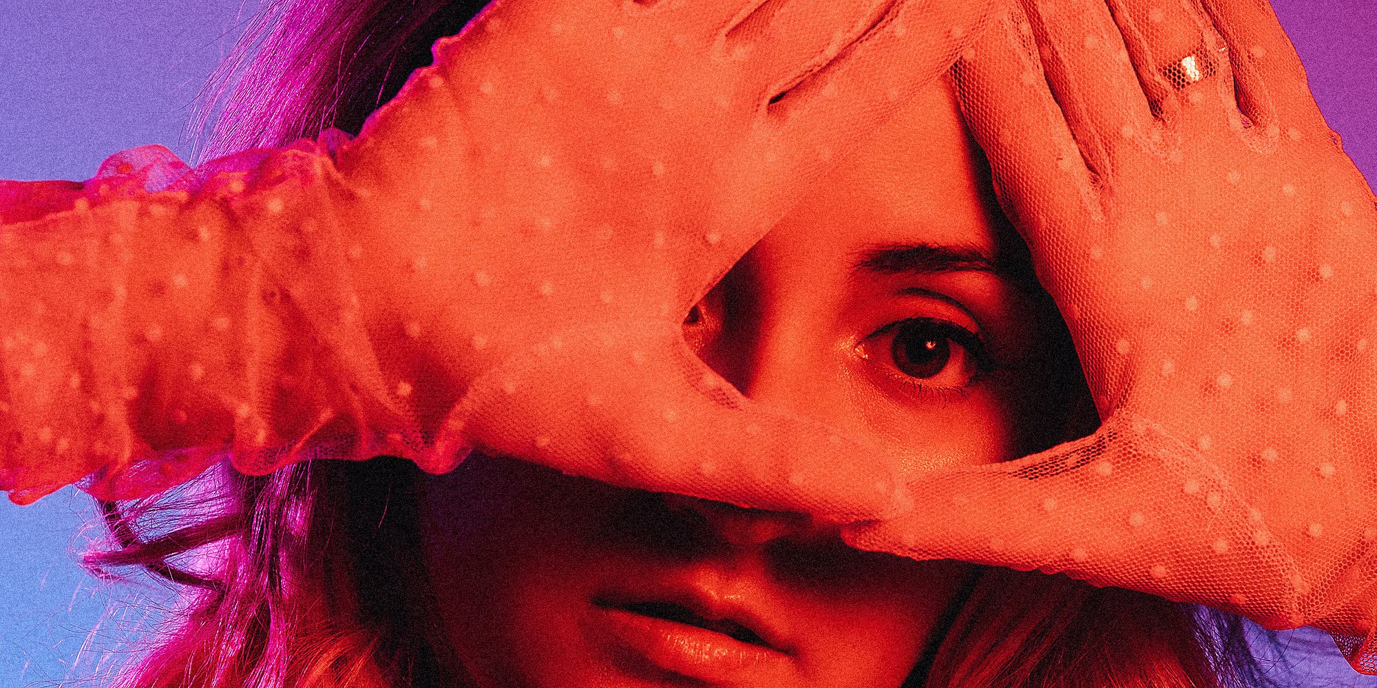 A woman makes a triangle over her eye.