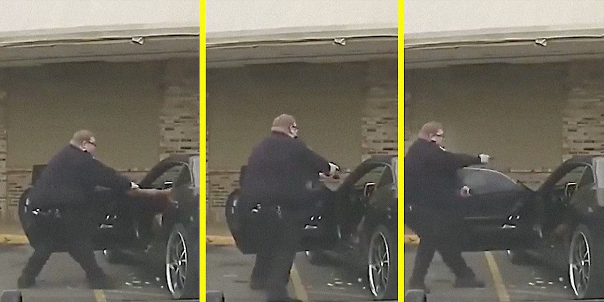 A cop pulls his gun on a person in a car.