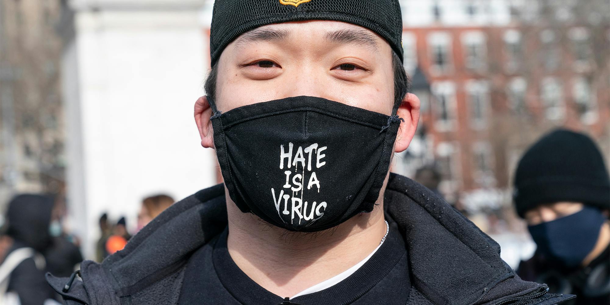 man wearing "hate is a virus" facemask at Washington Square Park rally in support Asian community, against hate crime and white nationalism