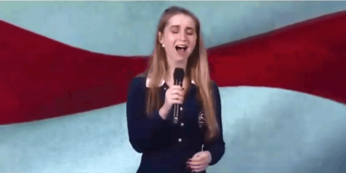 A woman singing the National Anthem at CPAC