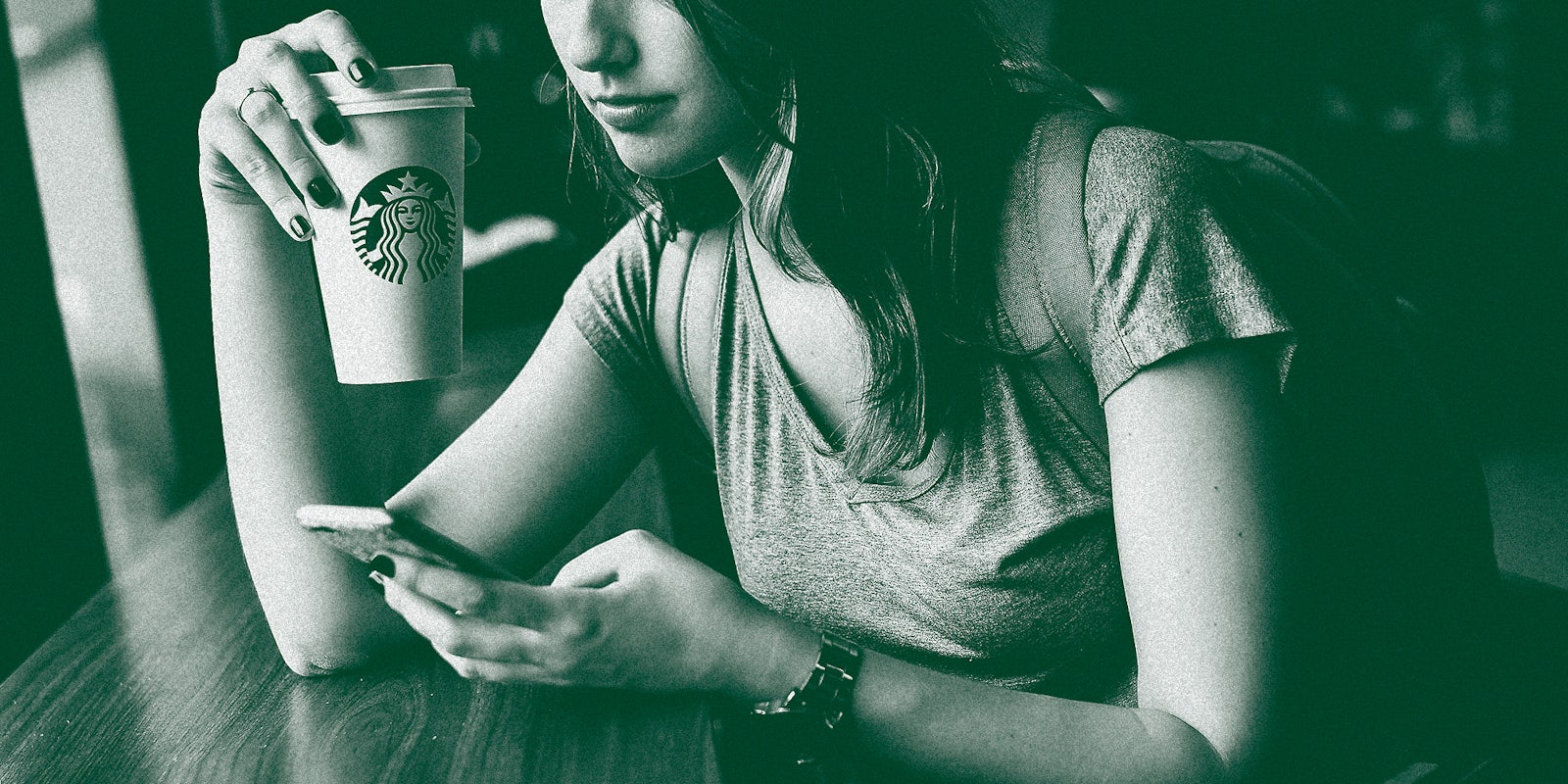 A woman drinking coffee on her phone.