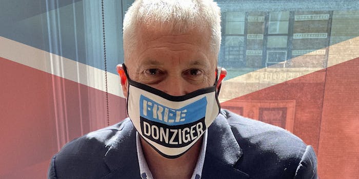 Steven Donziger wearing "Free Donziger" facemask over Chevron logo background
