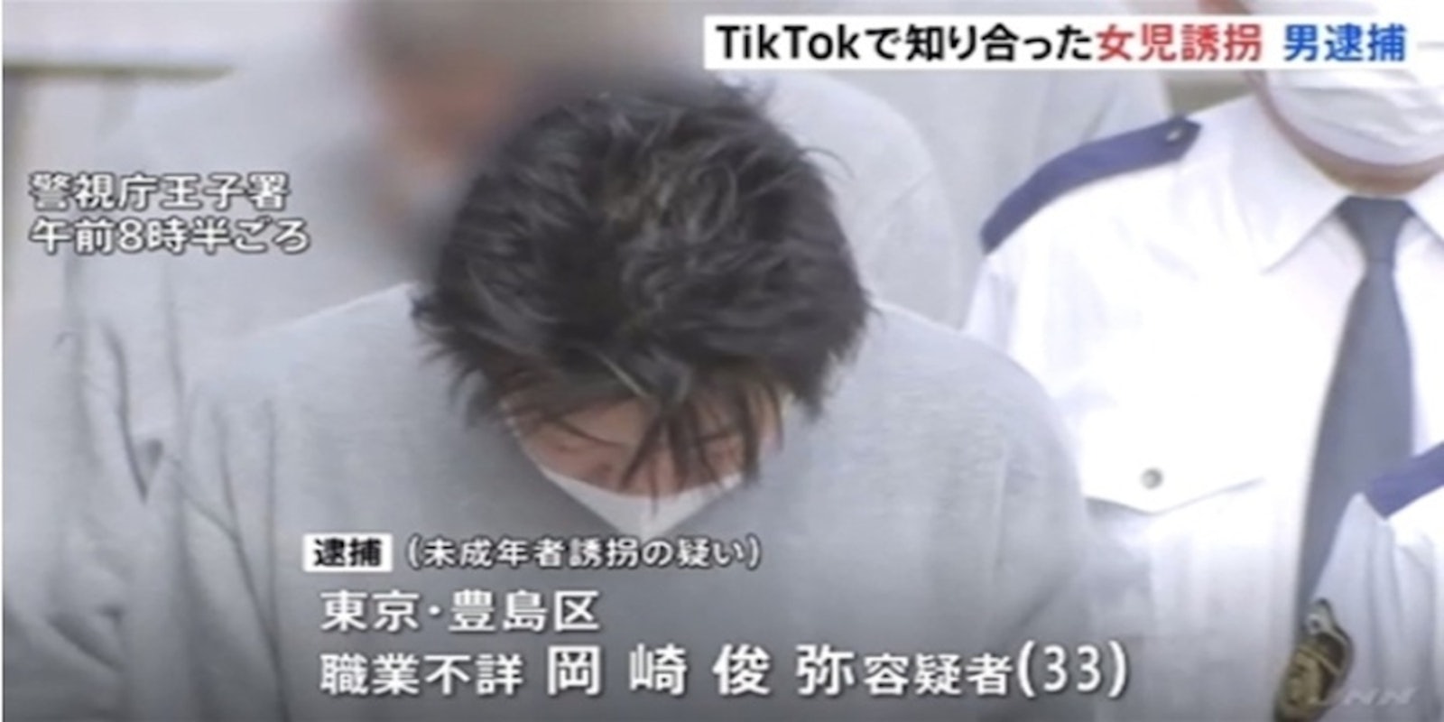 Man in Tokyo wearing a grey sweatshirt and white mask with his hands behind his back after being arrested for kidnapping girl he met on TikTok