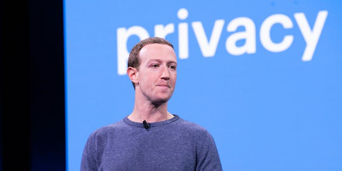 Facebook CEO Mark Zuckerberg talking on a stage in 2019 with the word 'privacy' displaying behind him.