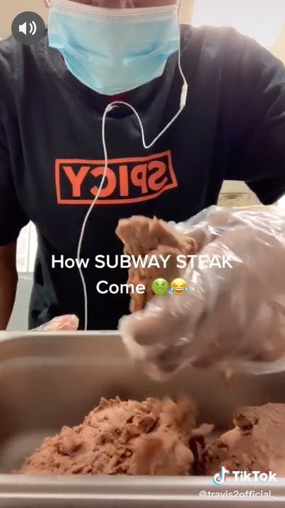 Subway worker mashing up chunk of subway steak