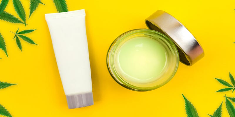 CBD lotion and salve on yellow background.