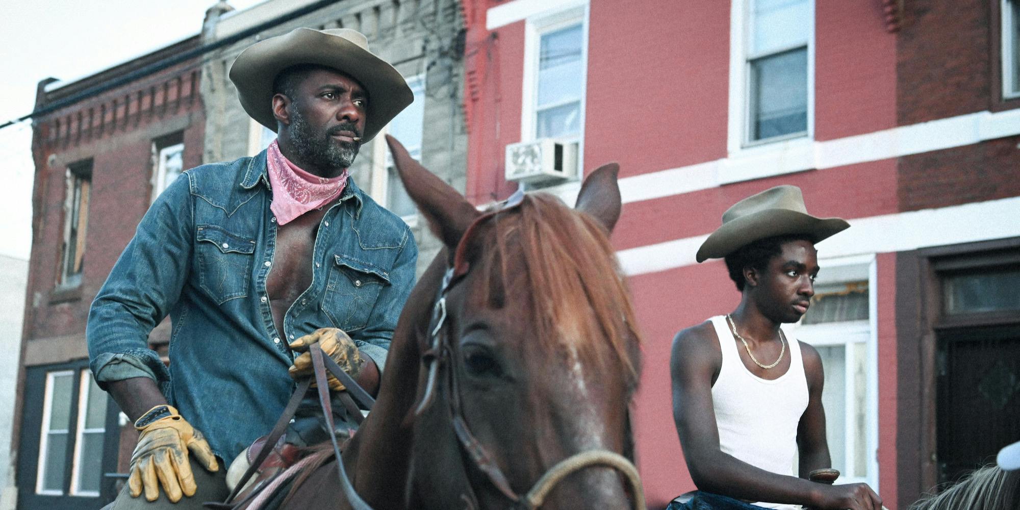 man and teenager riding on horses in a city