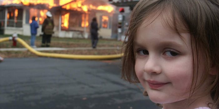 girl standing in front of a house on fire